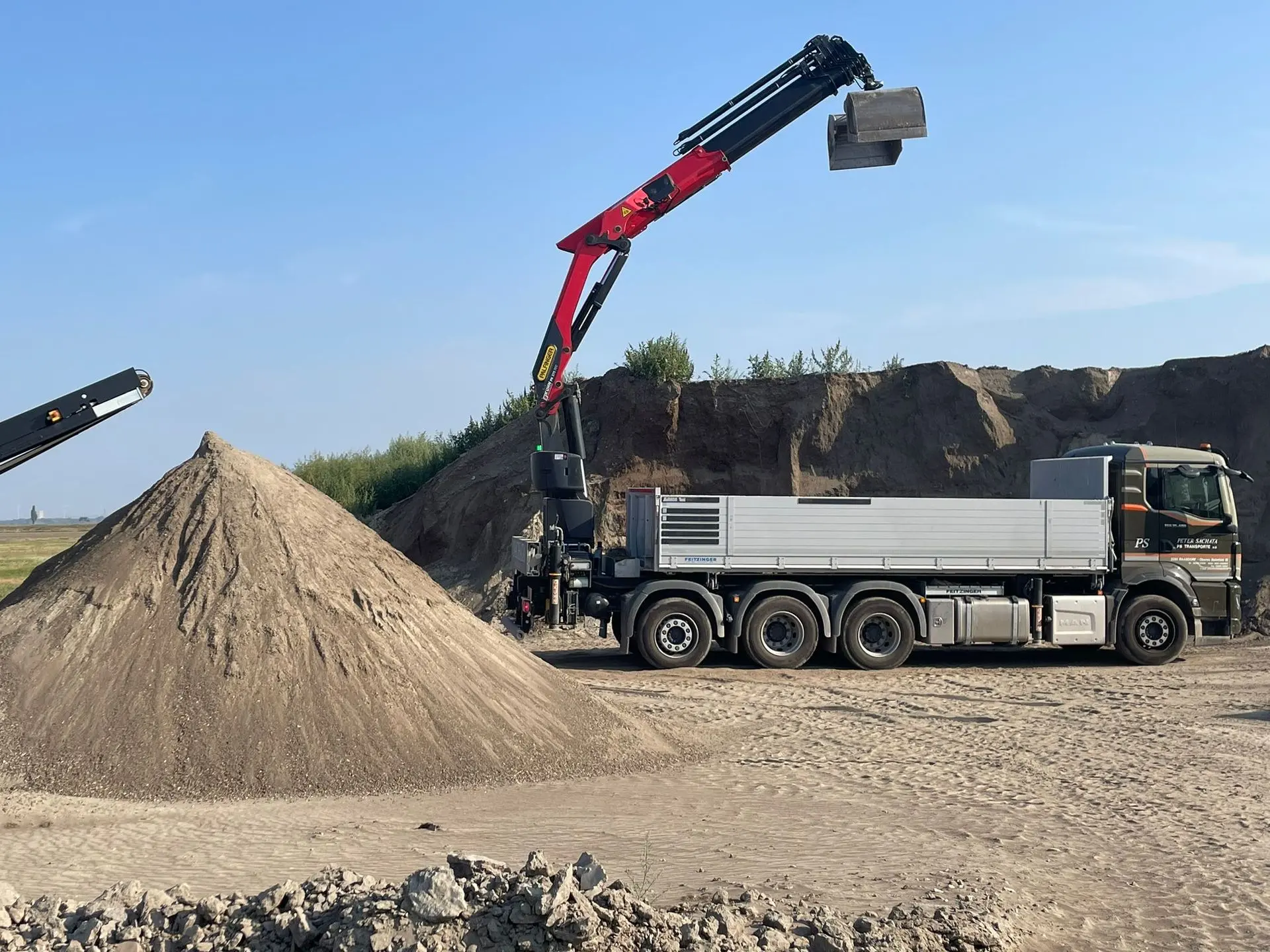 PS Transporte LKW mit Ladekran vor Rasenerde